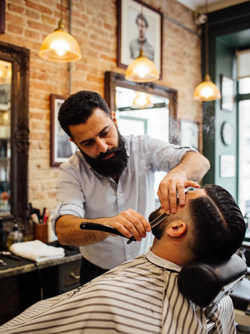Yusuf mentre rifinisce una barba con il rasoio